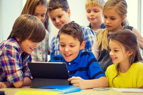 Group of young students working together at a tablet