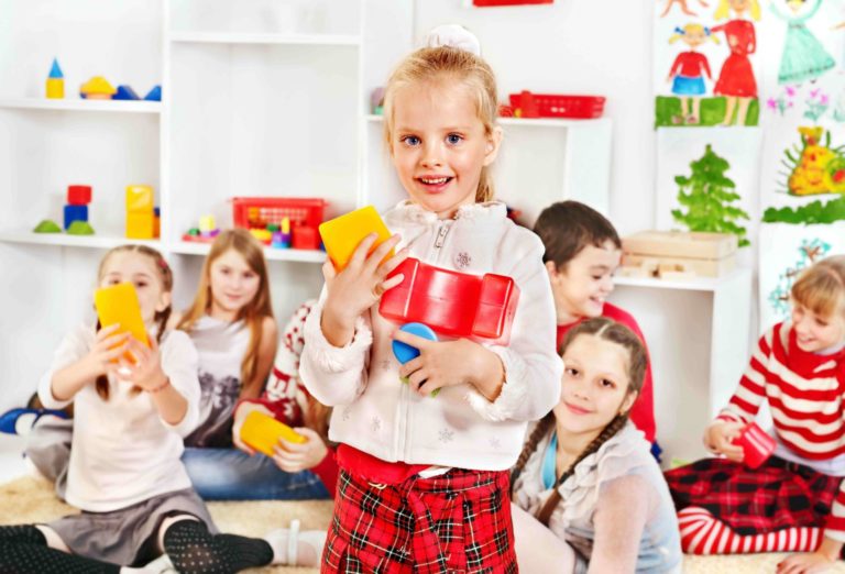 Young girl standing holding building blocks