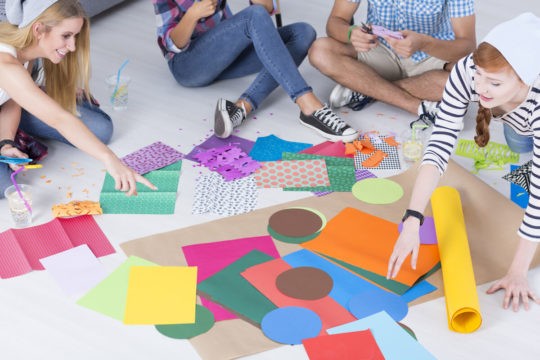 Older students sitting in a group working on an art project.