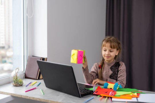 Young student creating art and sharing it on a laptop.