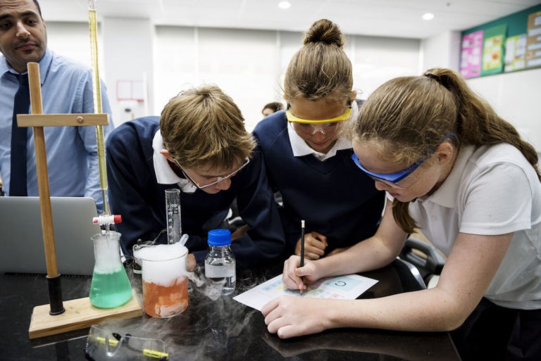 Students working on a science experiement together in a classroom.