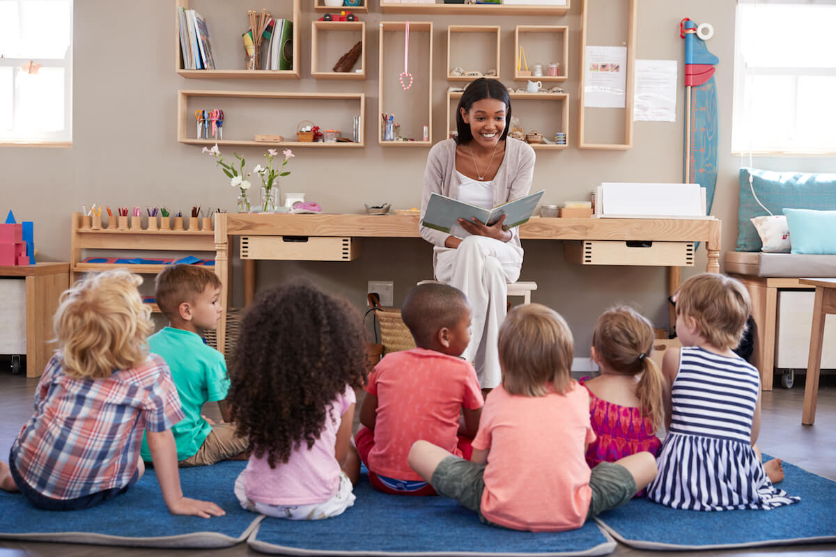 Female teacher reading to a group of young students