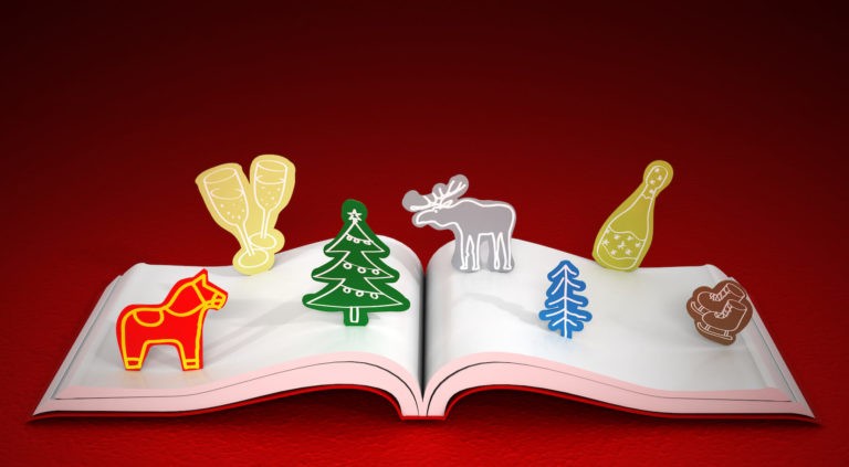 Open book with holiday shapes on the pages on a read background.