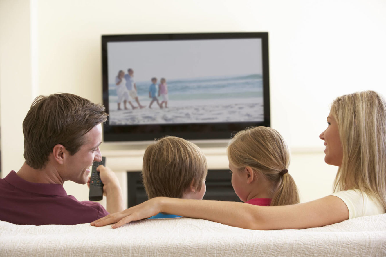 Family sitting on the couch watching tv