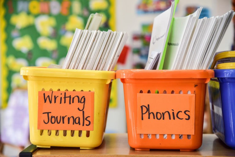 Labeled bins of papers in a classroom.