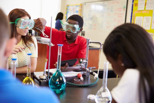 Group of high school students working together on a chemistry lab.