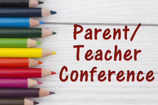 The words parent teacher conference written out with a photo of colored pencils