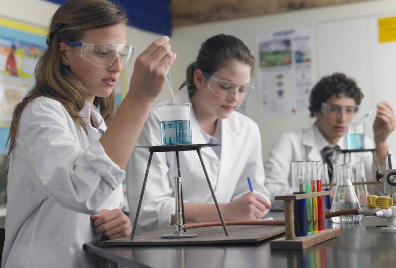 High school students working with chemicals wearing lab equipment