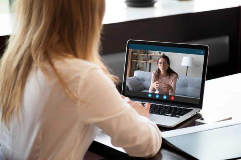 Woman talking to another woman over a Zoom call.