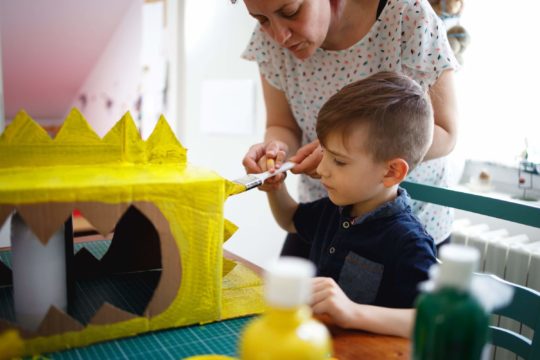 Mother and young son working on a craft project together.