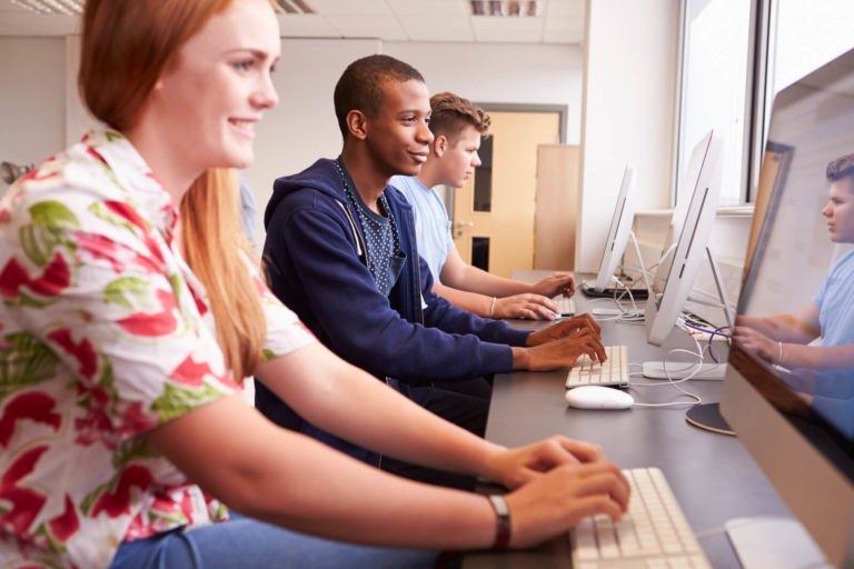 High school students working at a row of computers.