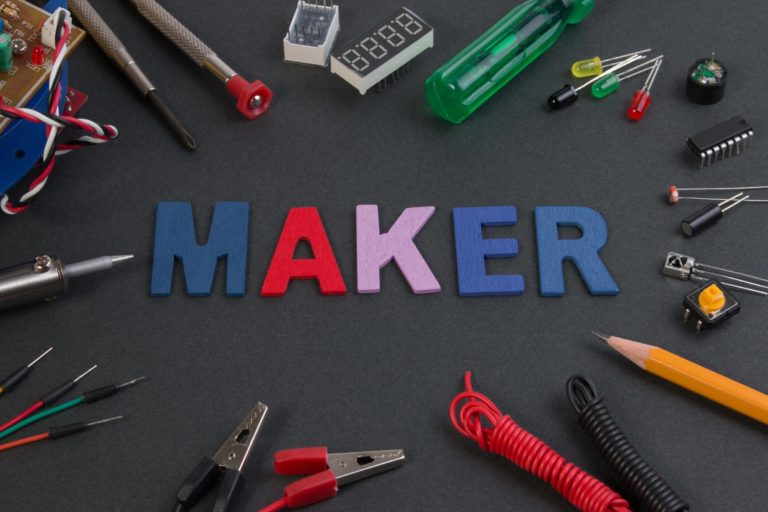 The word ‘maker’ surrounded by tools, wires, and more.